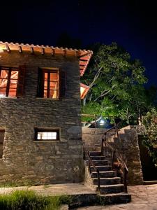 una casa in pietra con scale che la conducono di notte di The Ambassador Residence - Traditional stone house a Katochori