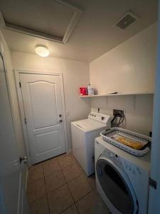 a small kitchen with a washing machine and a washer at Lady T’s Serenity Getaway near TUS airport in Tucson