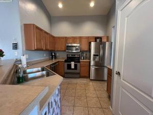 a kitchen with wooden cabinets and stainless steel appliances at Lady T’s Serenity Getaway near TUS airport in Tucson