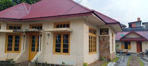 a house with a red roof and yellow doors at PONDOK SITI RAWIYAH in Bukittinggi