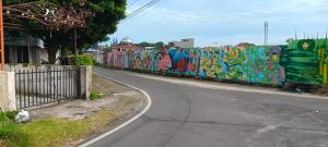 a street with a wall covered in graffiti at PONDOK SITI RAWIYAH in Bukittinggi