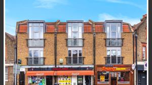 a large brick building with windows on a street at Twickenham studio private apartment in Twickenham