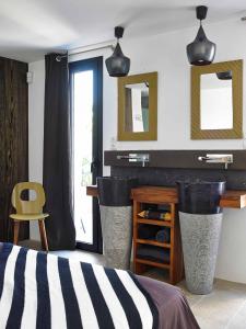 a bedroom with a bed and a desk and mirrors at Villa Ha Taew in Sant Josep de sa Talaia
