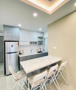 una cucina con tavolo, sedie e frigorifero di Irizz Inn @Homestay Platinum Splendor a Kuala Lumpur