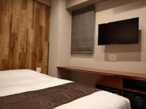a bedroom with a bed and a flat screen tv at HOTEL ERENOA - Vacation STAY 61024v in Nagoya