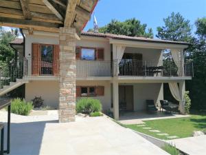 a house with a balcony and a patio at Villa VinoSelo mit Sauna & Whirlpool in Vižinada