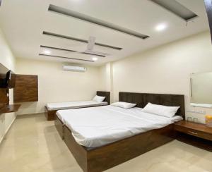 a bedroom with two beds and a flat screen tv at Naman Homestay in Amritsar