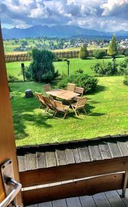 a wooden table and chairs in a field of grass at Mountain cozy house in Tatras in Ząb