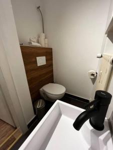 La salle de bains est pourvue de toilettes blanches et d'un lavabo. dans l'établissement Gemütliche 1 Zimmer Wohnung in Bahnhofsnähe, à Hildesheim