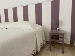 um quarto com uma cama e uma mesa com um candeeiro em Casina Terravecchia em Vibo Valentia