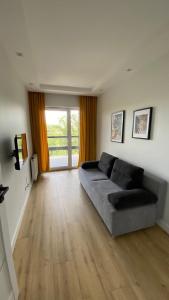 uma sala de estar com um sofá e uma grande janela em ApartamentMzTower em Kielce