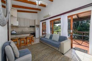 a living room with a blue couch and a kitchen at San Lameer Villa 1902 - 2 Bedroom Classic - 4 pax - San Lameer Rental Agency in Southbroom