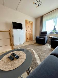 ein Wohnzimmer mit einem Tisch und einem TV in der Unterkunft Przyszowa 441 in Przyszowa