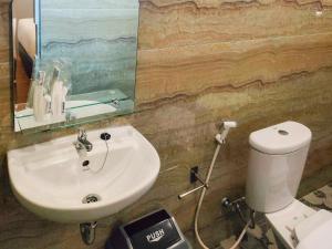 bagno con lavandino, servizi igienici e specchio di Travel Biz Hotel Medan Mitra RedDoorz a Medan