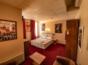 a hotel room with a bed and a window at Hôtel Le Colbert in Avignon