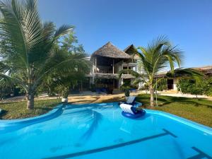 Villa con piscina frente a una casa en HOOM en Bwejuu