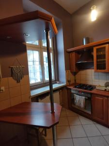kuchnia z drewnianym stołem i kuchenką w obiekcie Apartament na Rynku w Gnieźnie w Gnieźnie