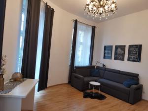 salon z kanapą i żyrandolem w obiekcie Apartament na Rynku w Gnieźnie w Gnieźnie