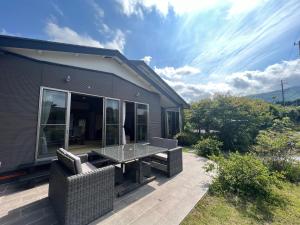 a patio with a table and chairs in front of a house at Den House in Oshima