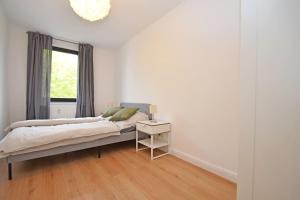a white bedroom with a bed and a window at Air Apartments 1 in Bremen