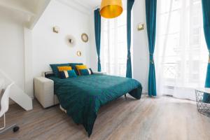 a bedroom with a green bed and blue curtains at Loft Latin in Paris
