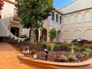 einen Garten vor einem Gebäude mit einem Baum in der Unterkunft Villa Elena Can Quintana in Pineda de Mar