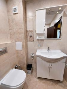a bathroom with a white sink and a toilet at Апартаменти за гости Делукс in Burgas City