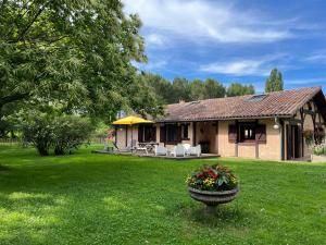 a house with a flower pot in the yard at La bergerie des Landes in Lit-et-Mixe