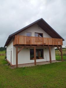 a house with a deck on top of it at Dom / Apartament Mazury przy jeziorze in Mrągowo