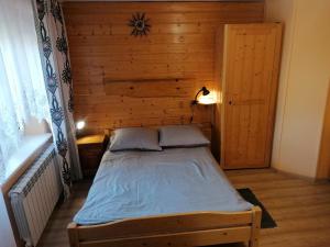 Cama en habitación con pared de madera en Wypoczynek u Bożeny i Edka Tkaczyków, en Grywałd