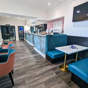 un ristorante con bancone, tavolo e sedie di Shaw Hill Hotel Golf And Country Club a Chorley