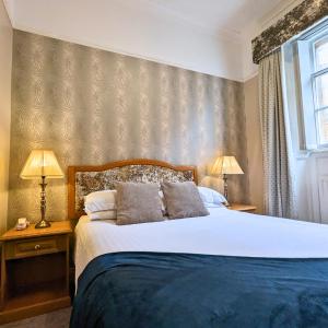 1 dormitorio con 1 cama grande y 2 lámparas en Shaw Hill Hotel Golf And Country Club, en Chorley
