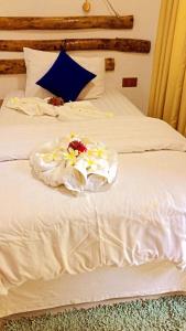 Una cama blanca con flores encima. en Rangali Etos Guraidhoo, en Guraidhoo
