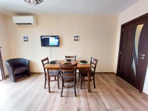 a dining room with a wooden table and chairs at Апартаменти за гости Делукс in Burgas City