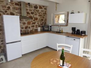 a kitchen with a table with a bottle of wine at Kerouzé in Bringolo
