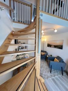 eine Treppe, die zu einem Wohnzimmer mit einem blauen Sofa führt in der Unterkunft Thuis op Texel in Den Burg