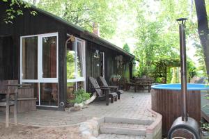 a cabin with a patio and a hot tub at PIE OPĪŠA in Cēsis