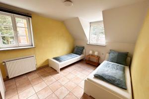 um pequeno quarto com duas camas e duas janelas em Nüssenberger Hof Apartments em Colônia