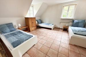 sypialnia na poddaszu z 2 łóżkami i kanapą w obiekcie Nüssenberger Hof Apartments w Kolonii