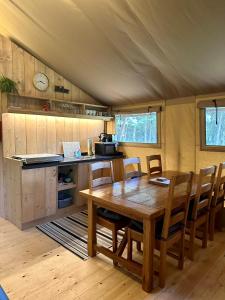 a kitchen and dining room with a table and chairs at Cherry Tree Safari Lodge in Talaton