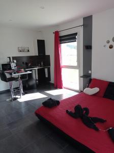 a bedroom with a red bed and a desk at Paradis Secret Spa in Damprichard