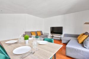 uma sala de estar com uma mesa e um sofá em Appartement Quartier Republique em Paris