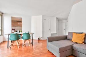 a living room with a couch and two green chairs at Appartement Quartier Republique in Paris