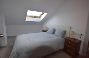 a bedroom with a bed and a skylight at Apartamento Mar de Ardora Finisterre in Finisterre