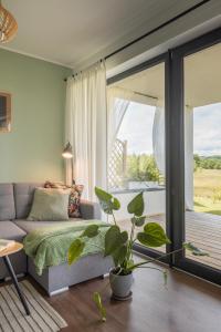 a living room with a couch and a large window at Klangor Mechowo in Mechowo