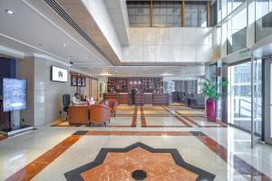 a lobby of a building with a desk and chairs at Majestic Premier Hotel Burdubai in Dubai