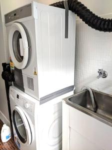 a kitchen with a washing machine and a sink at *Promo!* 2-Min to Train Station! in Melbourne