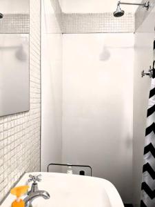 a white bathroom with a sink and a shower at *Promo!* 2-Min to Train Station! in Melbourne