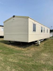 a large metal trailer parked in a field at Hidden Gem Getaways in Wyke Regis