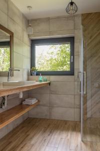ein Bad mit einer Dusche, einem Waschbecken und einem Fenster in der Unterkunft Klangor Mechowo in Mechowo